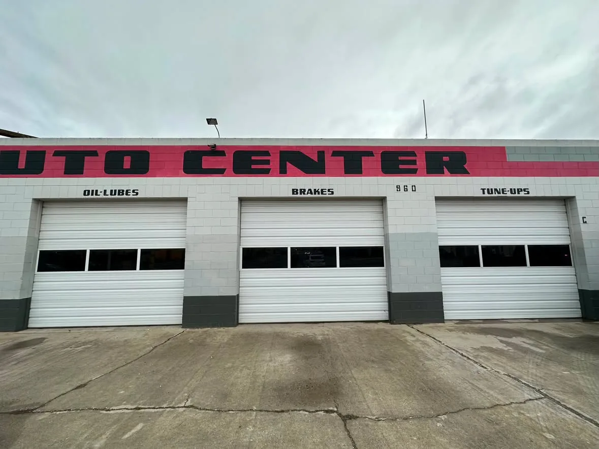 Commercial roll up doors with tinted glass panels at an auto center
