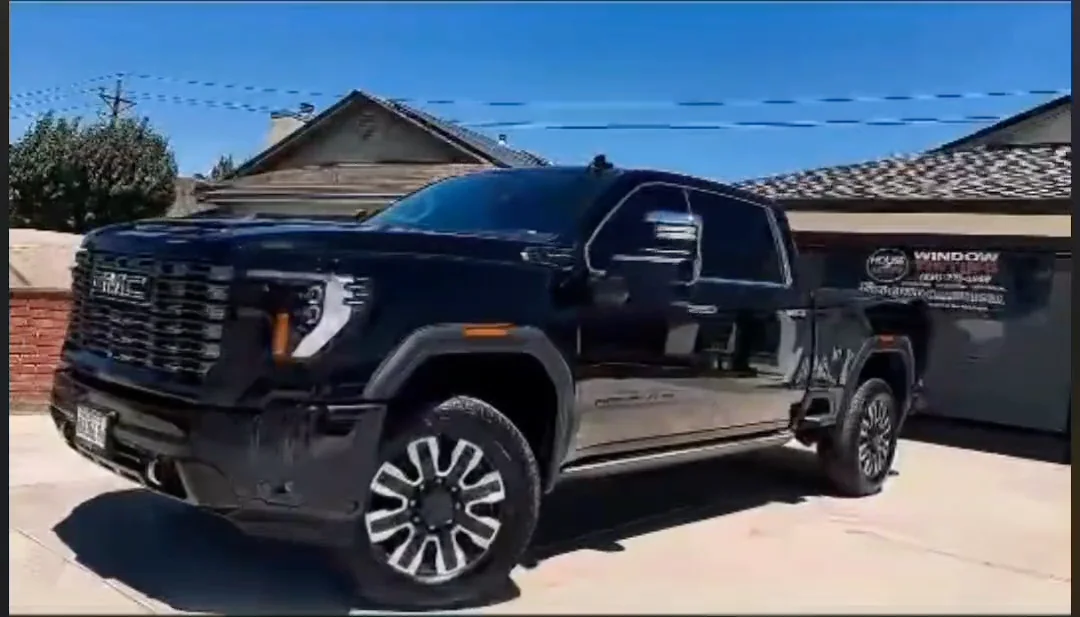 A black GMC Duramax pickup with tinted windows after the install