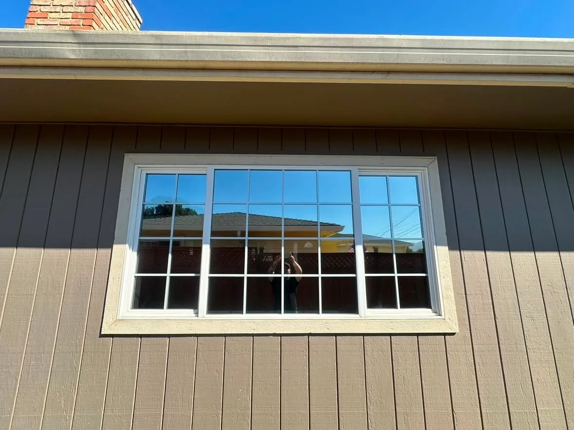 A grid window on a brown sided home after residential film